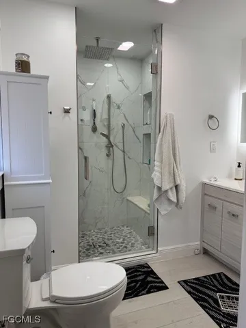 a bathroom with a granite countertop sink a toilet and shower