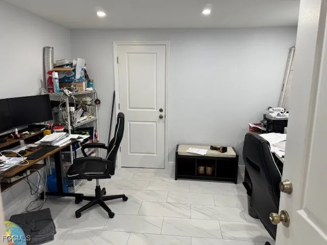 a view of a workspace with furniture and a window