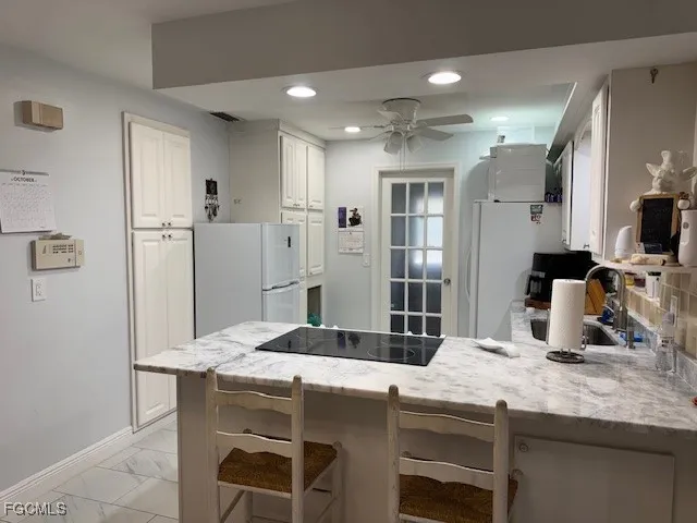 a kitchen with a table chairs refrigerator and microwave