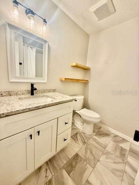 1819 Oak Street DeLand, FL 32724 - Photo 17 of 26 a bathroom with a granite countertop sink a toilet and a mirror