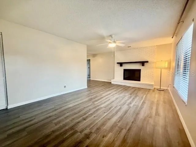 a view of empty room with wooden floor and fireplace