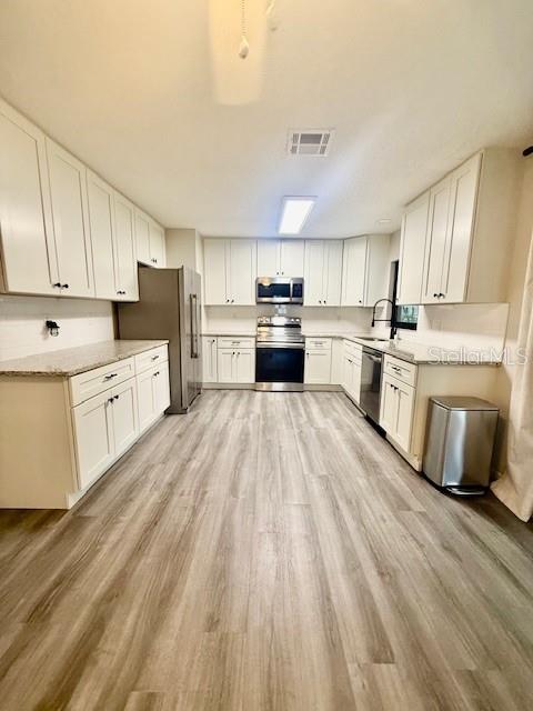 1819 Oak Street DeLand, FL 32724 - Photo 6 of 26 a kitchen with stainless steel appliances a stove top oven sink and cabinets