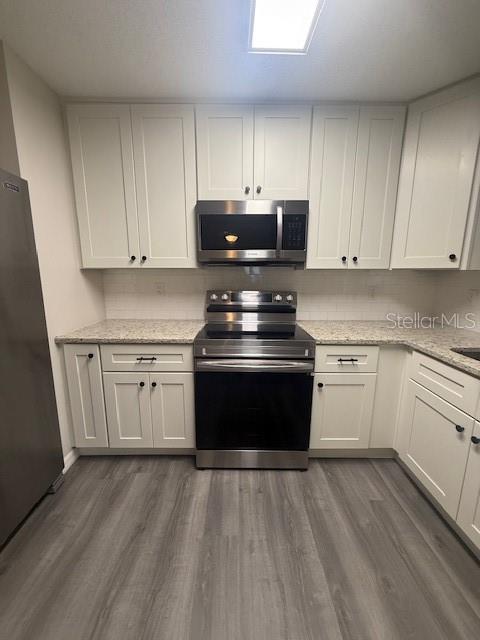 1819 Oak Street DeLand, FL 32724 - Photo 8 of 26 a kitchen with granite countertop a stove top oven a sink dishwasher and cabinets with wooden floor