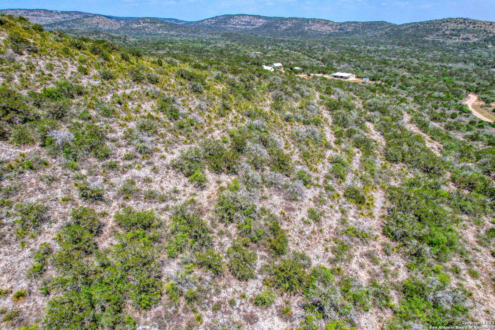 0 Brushy Creek Ranch Road Concan, TX 78838 - Photo 24 of 27 a view of a lush green field with a mountain in the background