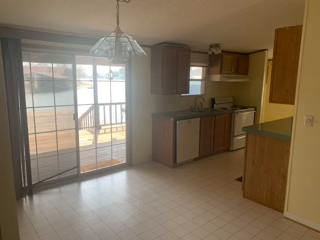 a kitchen with granite countertop a refrigerator and a sink