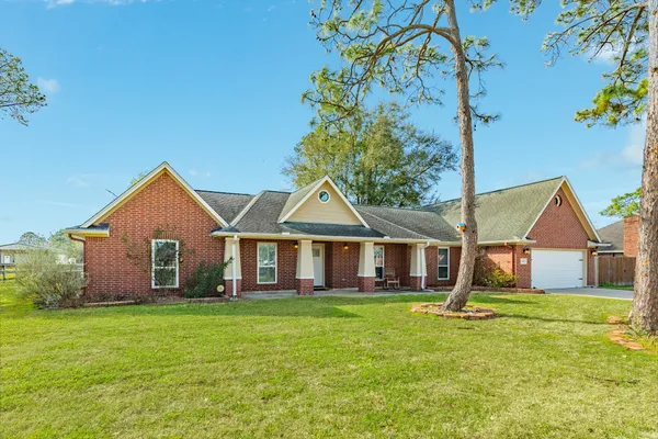 a front view of a house with a yard and trees