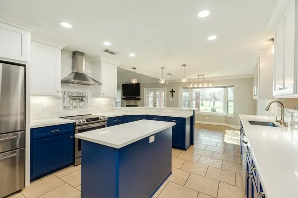 a large kitchen with kitchen island a sink counter space and appliances