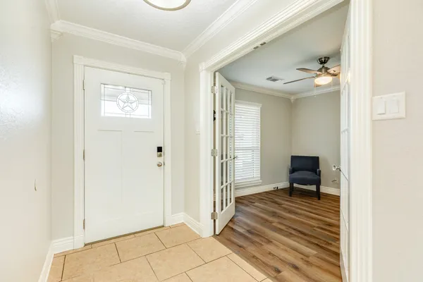 a view of a hallway with wooden floor and a bathroom
