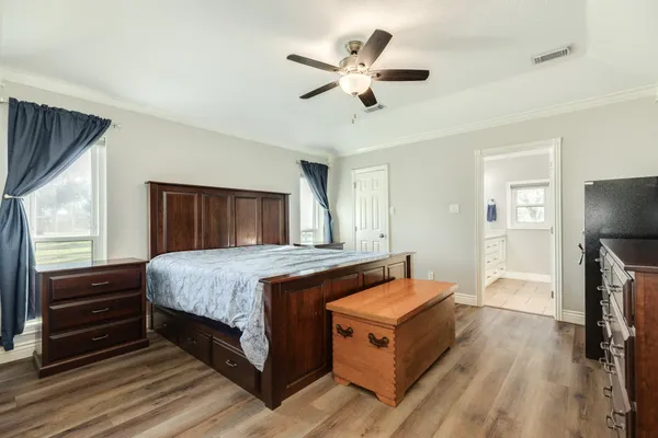 a spacious bedroom with a bed and a ceiling fan