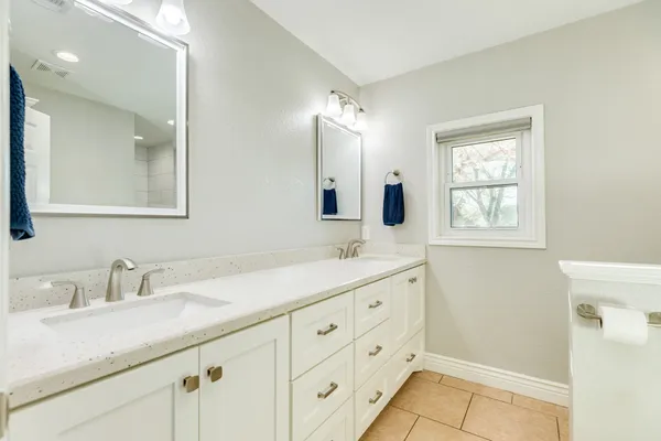 a bathroom with a granite countertop sink mirror and double