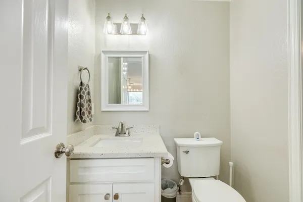 a bathroom with a granite countertop toilet sink and mirror