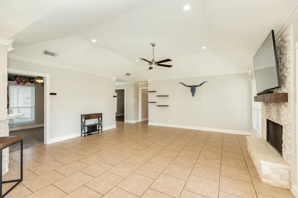 an empty room with fireplace and windows