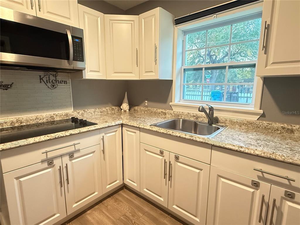 644 Indiana Street Orlando, FL 32805 - Photo 5 of 15 a kitchen with granite countertop white cabinets and a sink