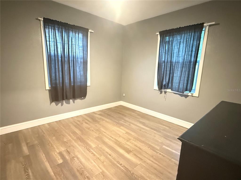 644 Indiana Street Orlando, FL 32805 - Photo 9 of 15 a view of an empty room with wooden floor and a window