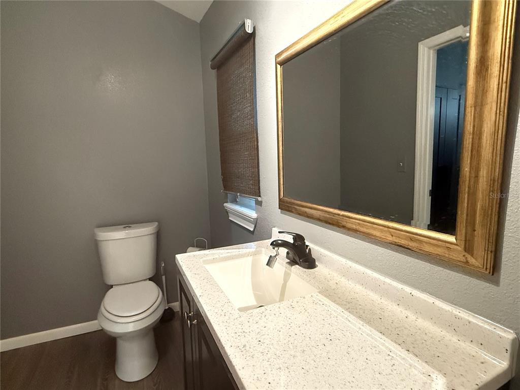644 Indiana Street Orlando, FL 32805 - Photo 10 of 15 a bathroom with a granite countertop toilet and a sink