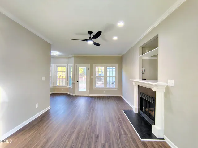 a view of empty room with a fireplace and wooden floor