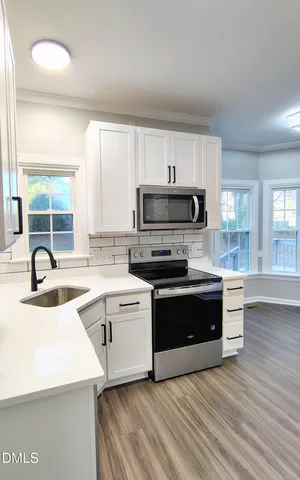 a kitchen with a sink a stove and cabinets