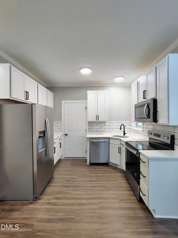 a kitchen with stainless steel appliances a refrigerator sink and cabinets