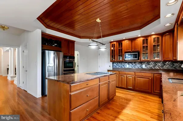 a large kitchen with stainless steel appliances granite countertop wooden cabinets a sink and dishwasher