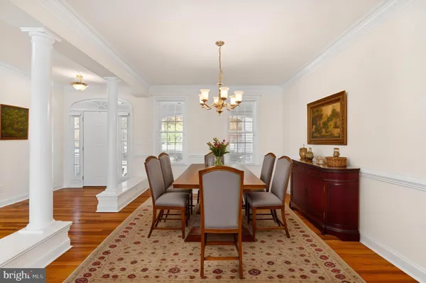 a dining room with furniture a chandelier and wooden floor