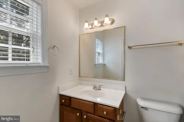 a bathroom with a sink vanity mirror and toilet
