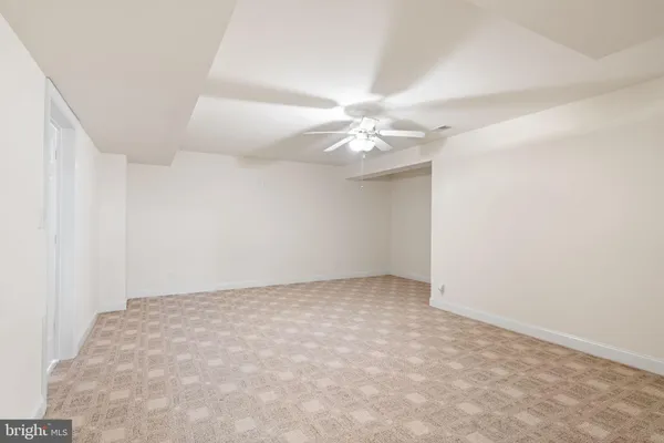 an empty room with a chandelier fan