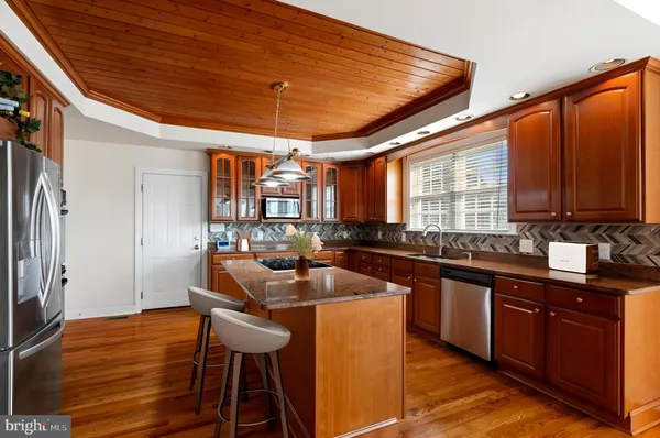 a kitchen with stainless steel appliances granite countertop a sink and wooden cabinets