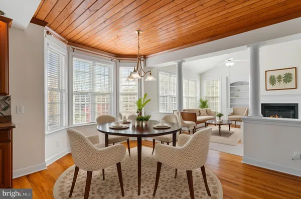 a dining room with furniture a chandelier and wooden floor