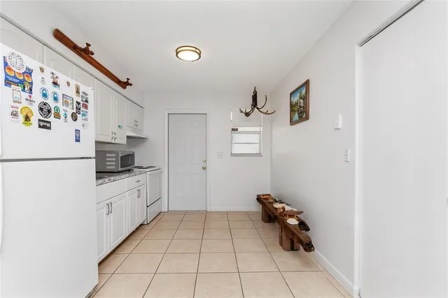 a kitchen with white cabinets and white appliances