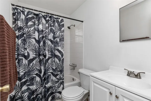 a bathroom with a granite countertop toilet and a sink