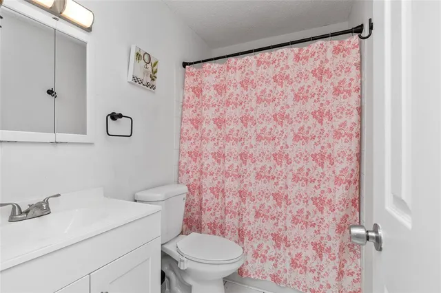a white toilet sitting next to a shower curtain