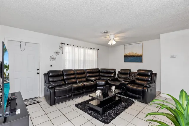 a dining room with furniture a chandelier and kitchen view