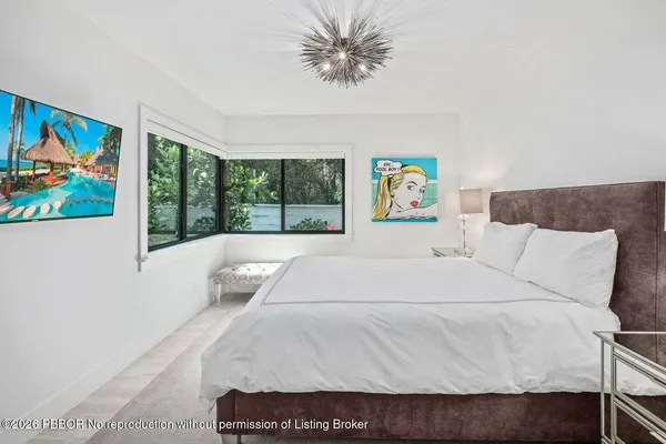 a bedroom with a bed and a large window