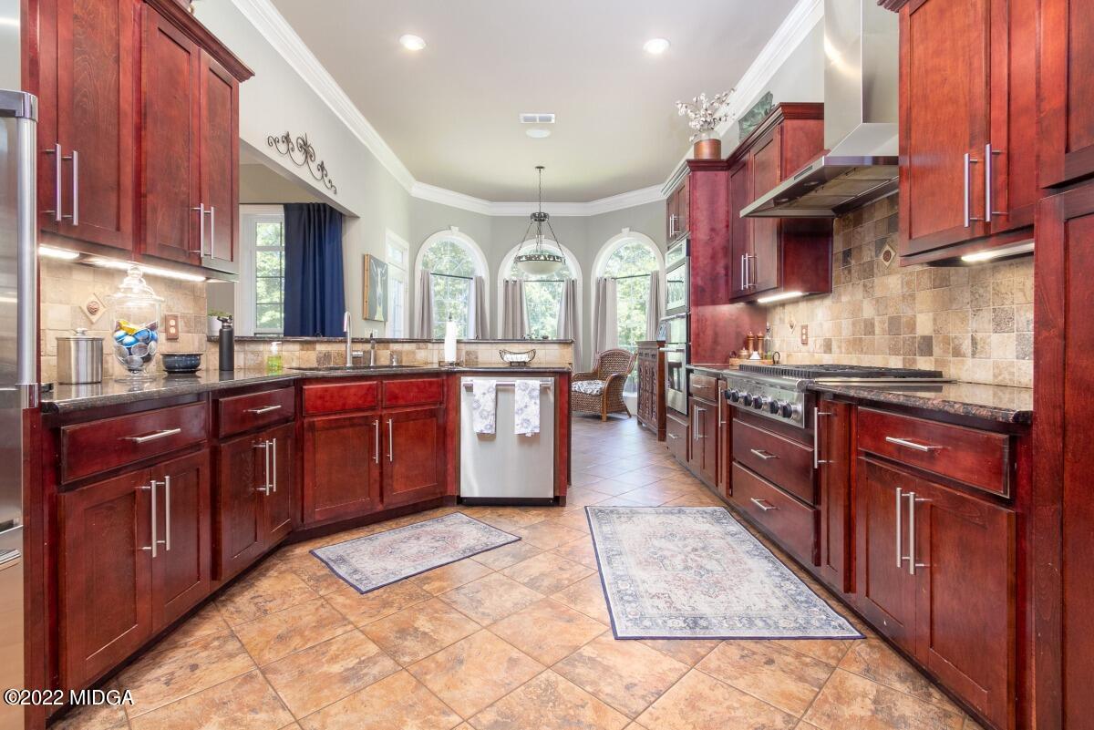 500 River Walk Forsyth, GA 31029 - Photo 11 of 31 a large kitchen with stainless steel appliances granite countertop wooden cabinets a sink and dishwasher