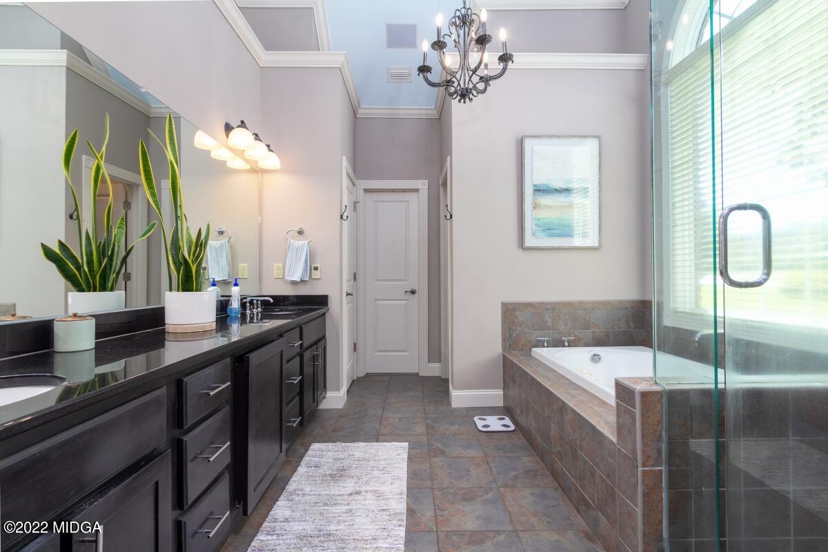 500 River Walk Forsyth, GA 31029 - Photo 15 of 31 a bathroom with a double vanity sink a large mirror and a bathtub
