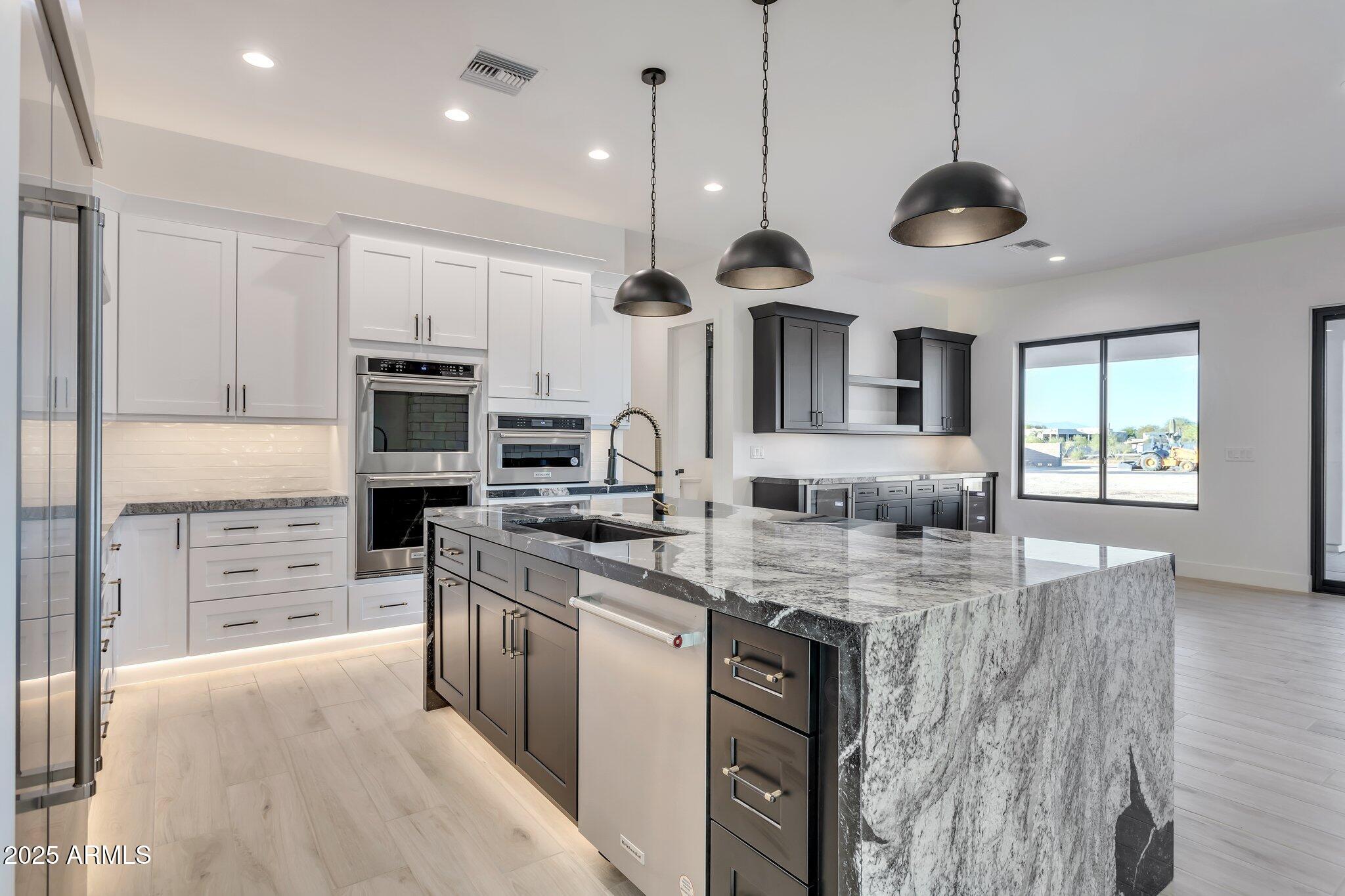 1602 East Cloud Road Phoenix, AZ 85086 - Photo 12 of 45 a kitchen with stainless steel appliances granite countertop a sink a stove and a wooden floors