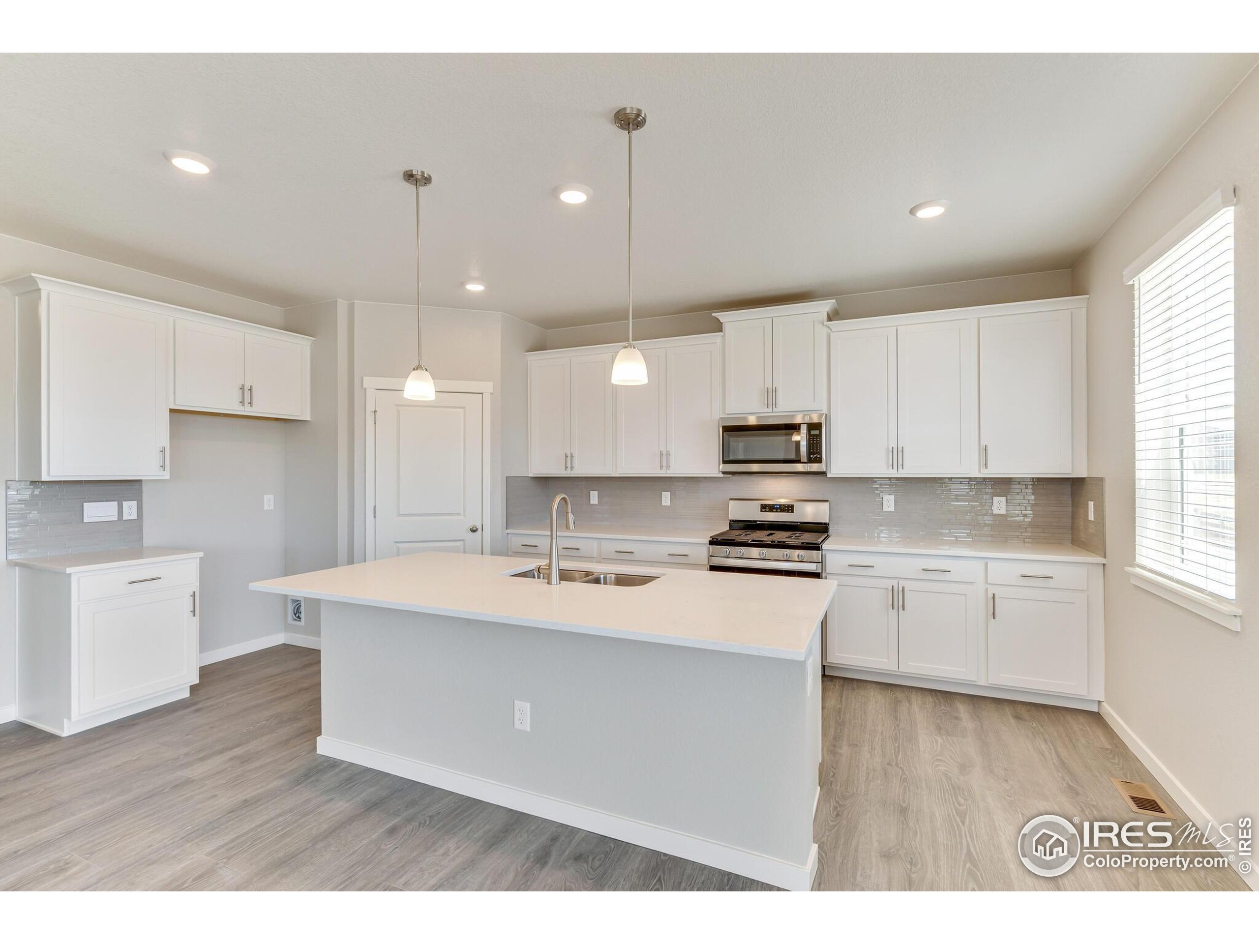 1894 Chaffee Crest Drive Berthoud, CO 80513 - Photo 12 of 31 a kitchen with kitchen island a sink stainless steel appliances and cabinets