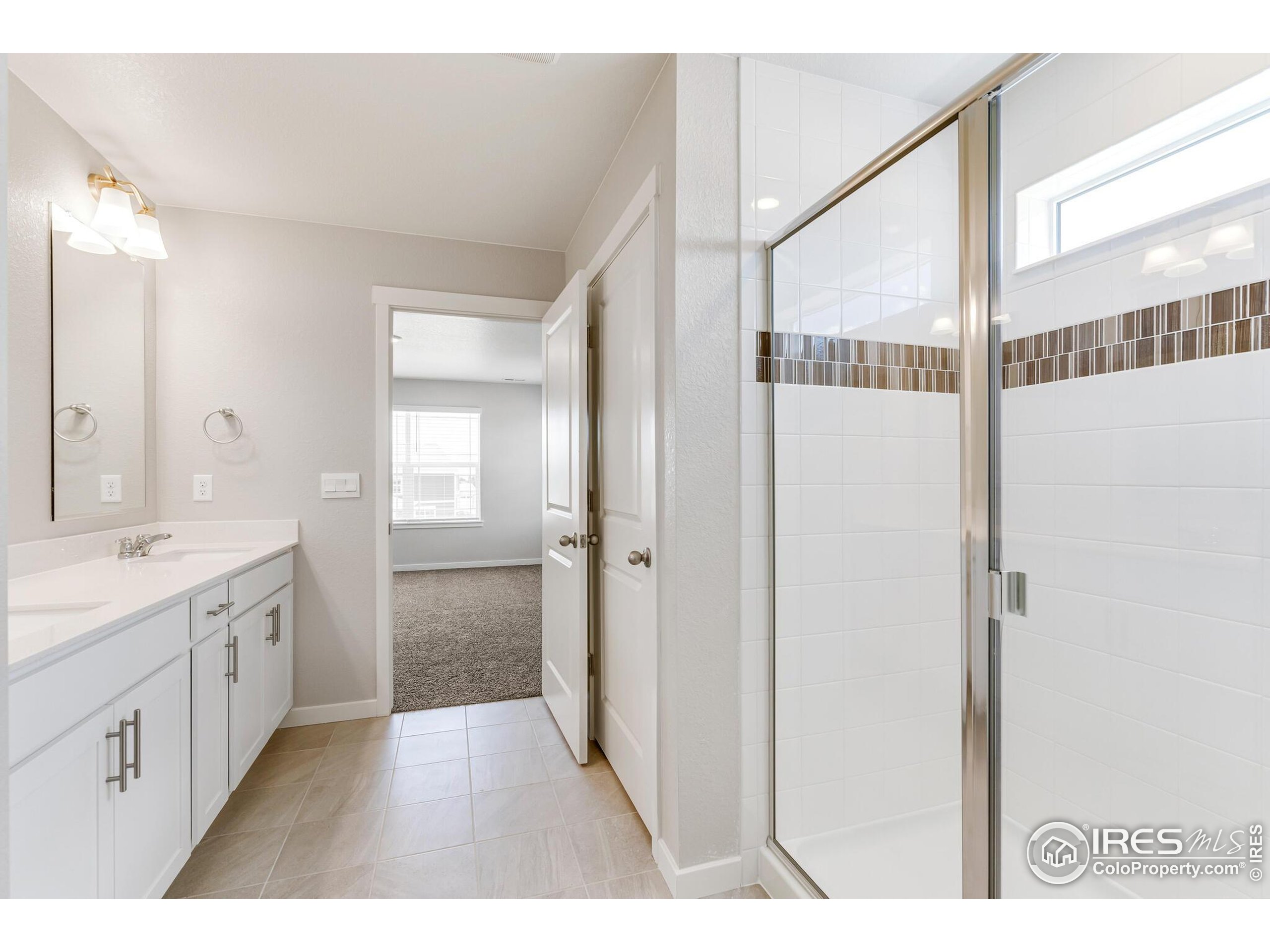 1894 Chaffee Crest Drive Berthoud, CO 80513 - Photo 18 of 31 a bathroom with a double vanity sink and mirror