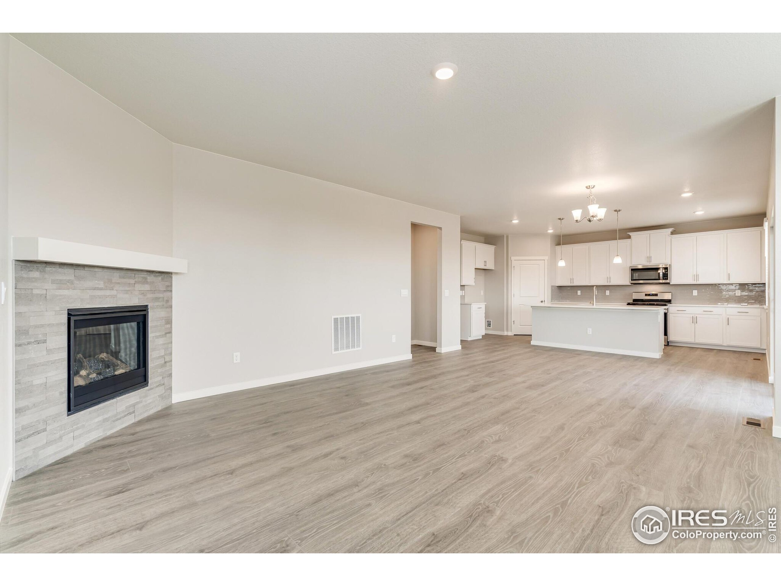 1894 Chaffee Crest Drive Berthoud, CO 80513 - Photo 6 of 31 a view of kitchen and empty room with wooden floor