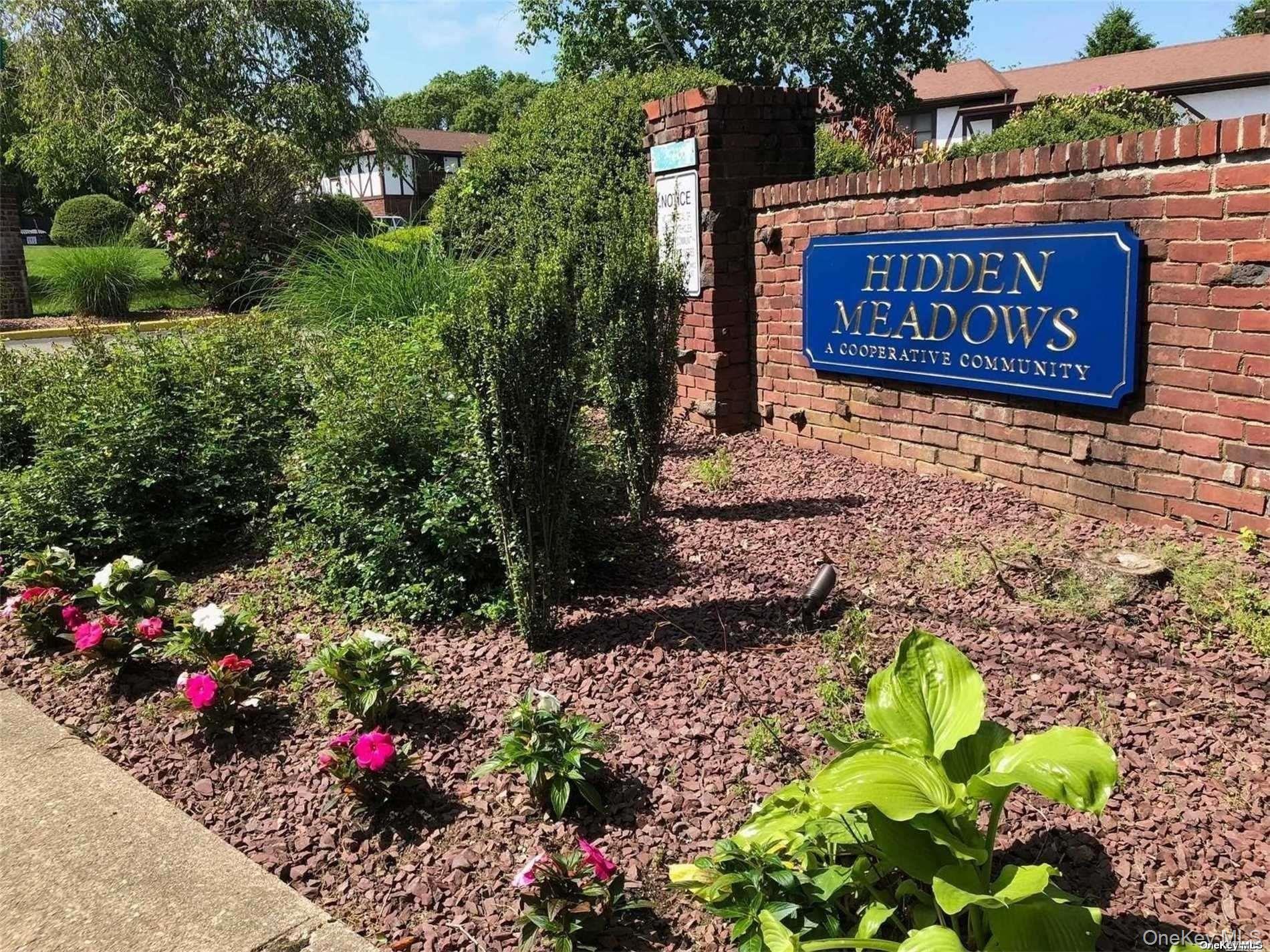 26 Bailey Court, Unit 26 Middle Island, NY 11953 - Photo 14 of 16 a sign that is in front of flowers