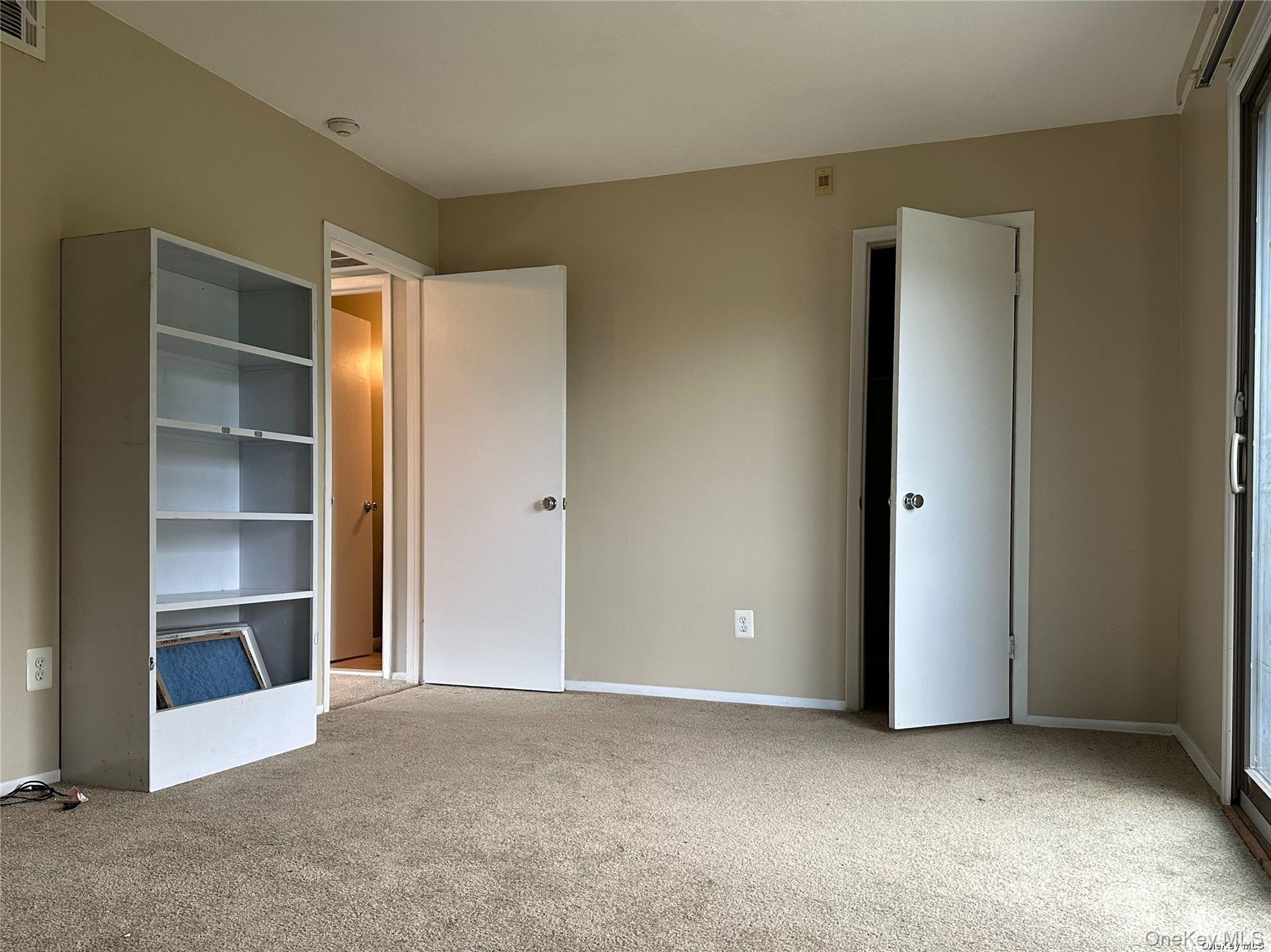 26 Bailey Court, Unit 26 Middle Island, NY 11953 - Photo 8 of 16 a view of an empty room with wooden floor and a cabinet