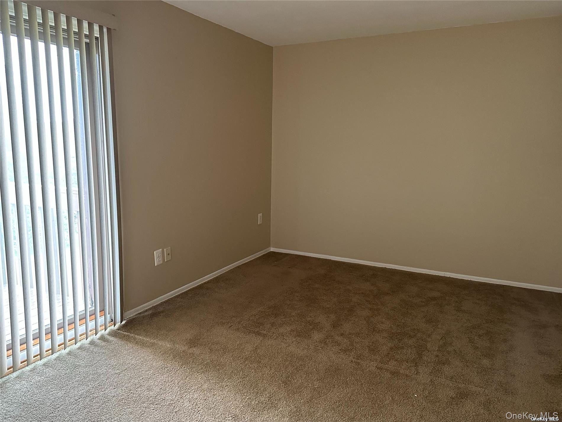 26 Bailey Court, Unit 26 Middle Island, NY 11953 - Photo 9 of 16 an empty room with a empty space and windows