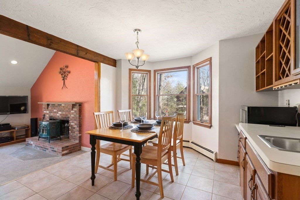 166 Edge Hill Road Sharon, MA 02067 - Photo 15 of 34 a dining room with furniture a fireplace and wooden floor