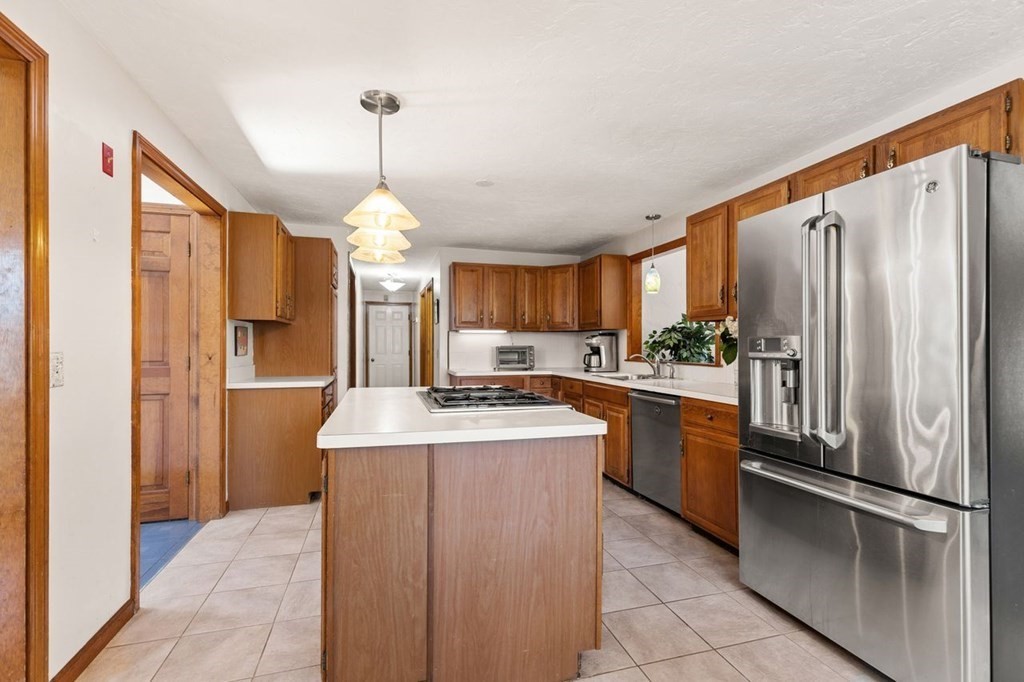 166 Edge Hill Road Sharon, MA 02067 - Photo 19 of 34 a kitchen with stainless steel appliances granite countertop a refrigerator a sink dishwasher with a dining table and chairs