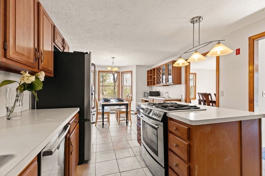 166 Edge Hill Road Sharon, MA 02067 - Photo 22 of 34 a kitchen with stainless steel appliances granite countertop a stove a sink dishwasher and a refrigerator with wooden floor