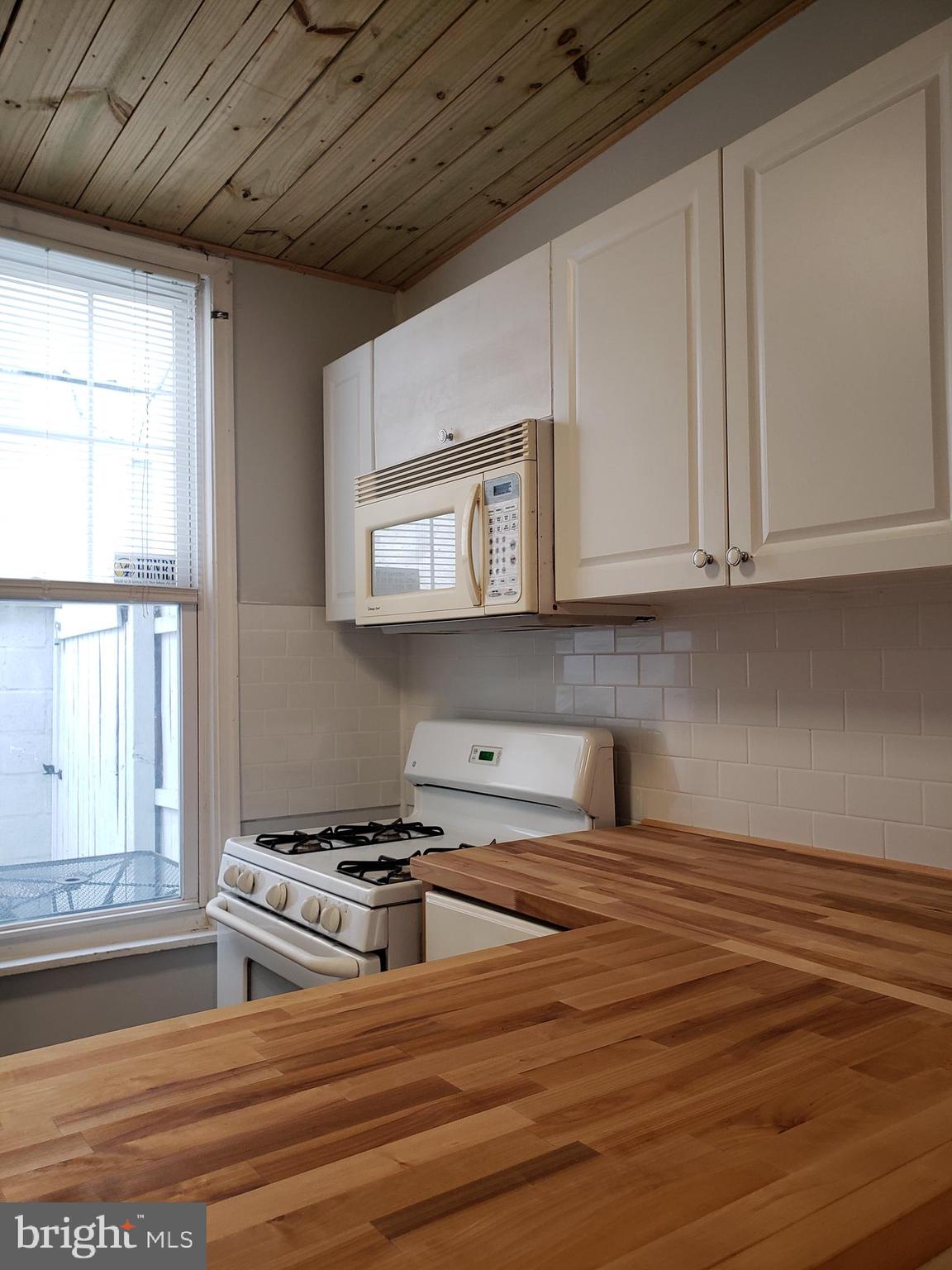 1623 Webster Street Philadelphia, PA 19146 - Photo 13 of 36 a kitchen with stainless steel appliances granite countertop a stove a sink and a microwave
