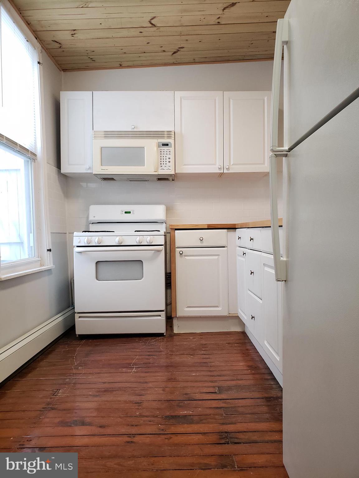 1623 Webster Street Philadelphia, PA 19146 - Photo 14 of 36 a kitchen with white cabinets appliances and a window