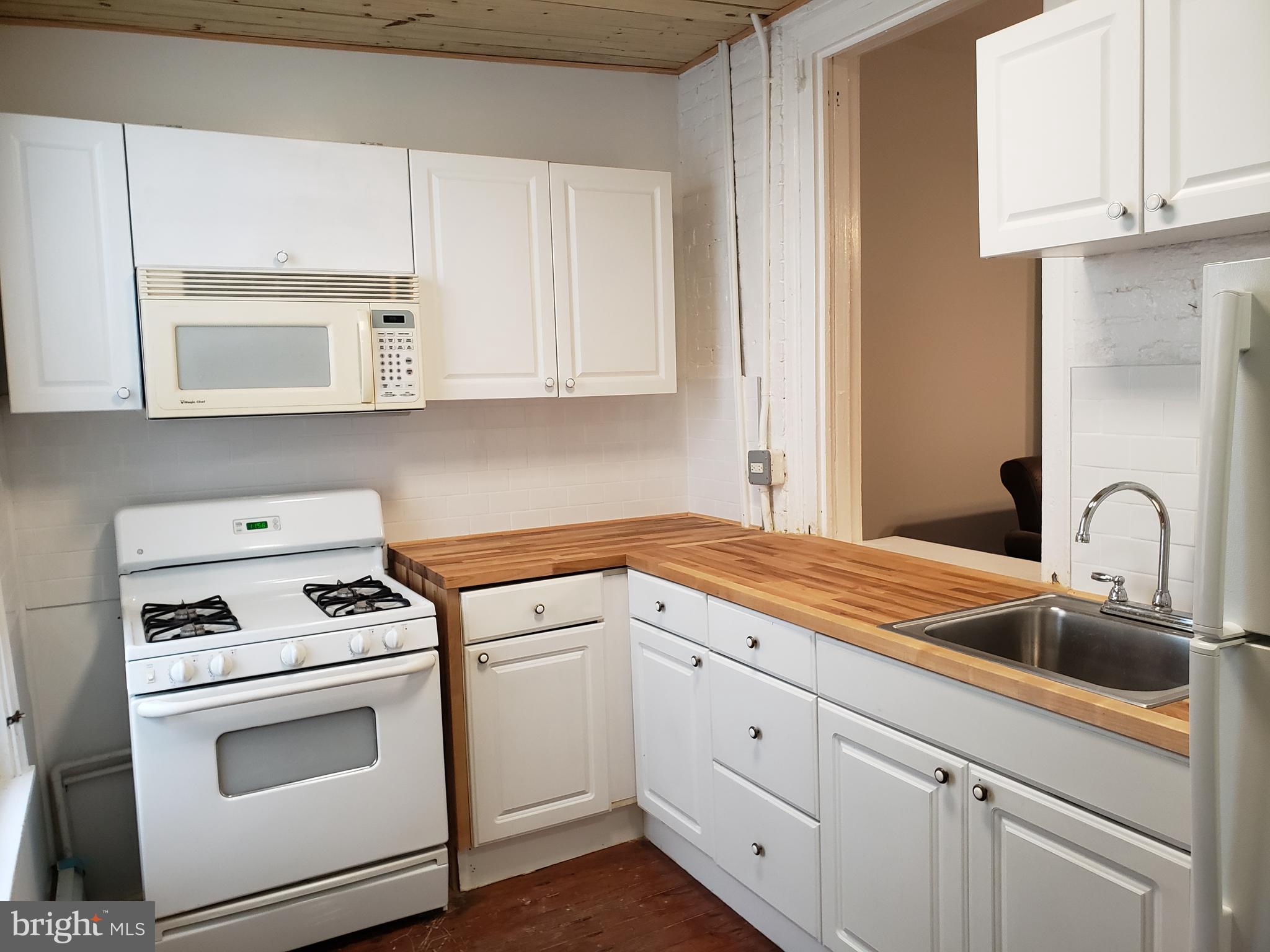 1623 Webster Street Philadelphia, PA 19146 - Photo 16 of 36 a kitchen with white cabinets and white appliances