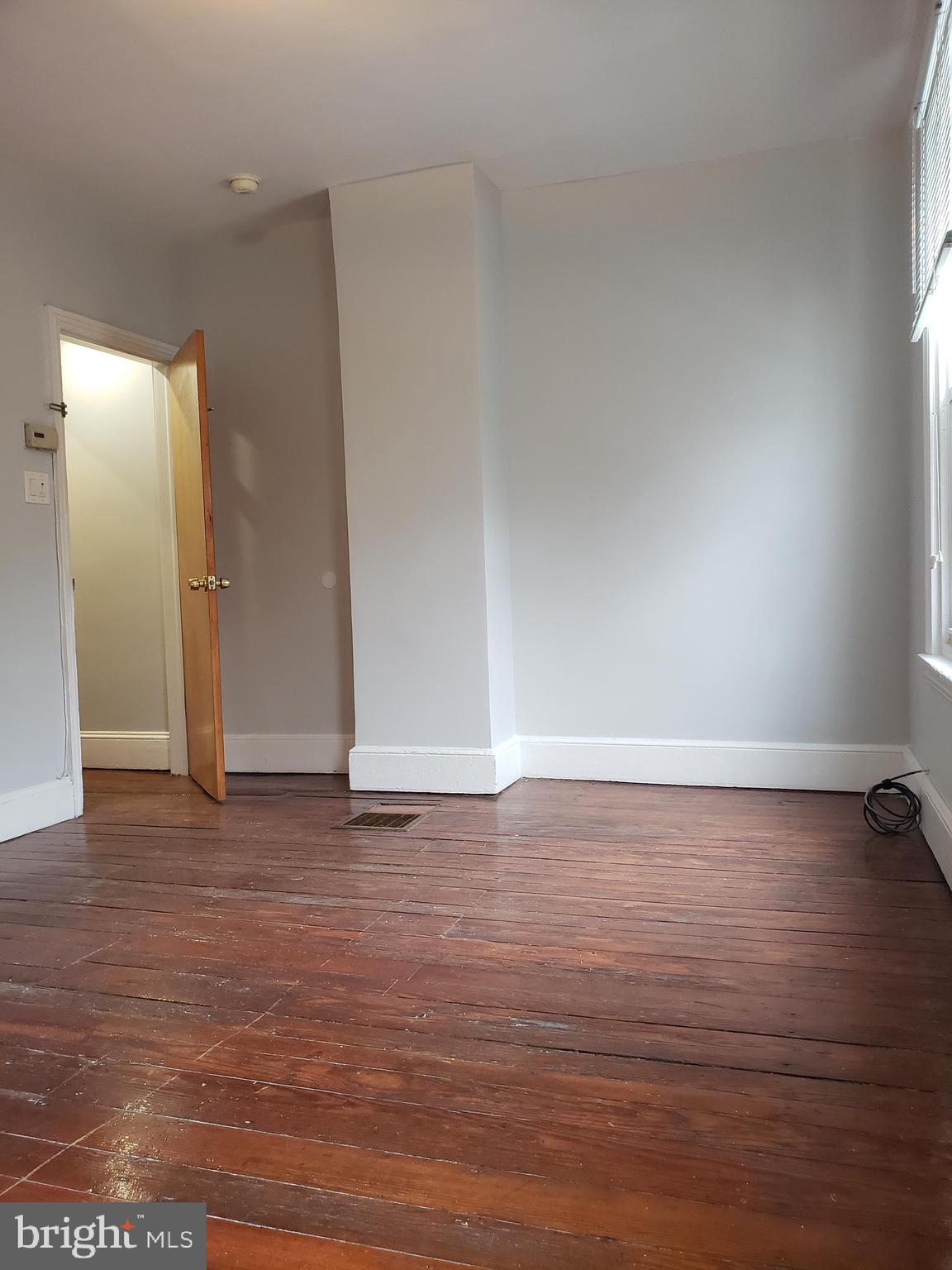 1623 Webster Street Philadelphia, PA 19146 - Photo 26 of 36 a view of an empty room with wooden floor and a window