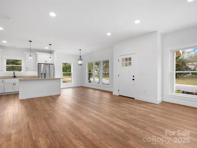 a kitchen with stainless steel appliances granite countertop a stove a sink and a refrigerator
